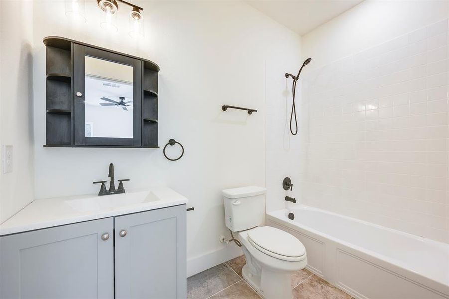 Full bathroom with bathtub / shower combination, vanity, and light tile patterned flooring