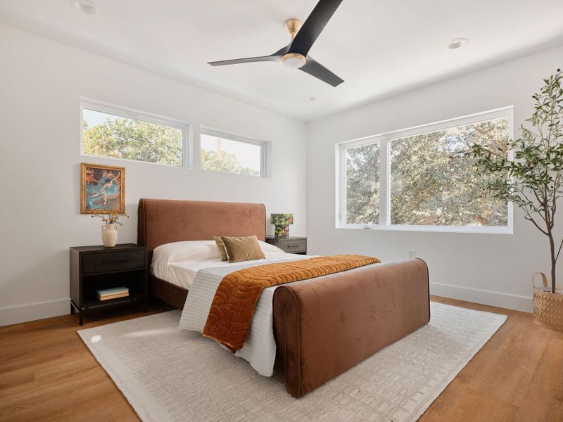 Bedroom with multiple windows, ceiling fan, light wood-type flooring, and recessed lighting Bedroom with multiple windows, ceiling fan, light wood-type flooring, and recessed lighting