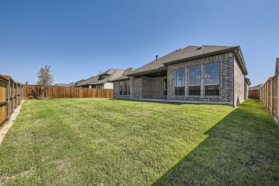 Rear view of house featuring a lawn