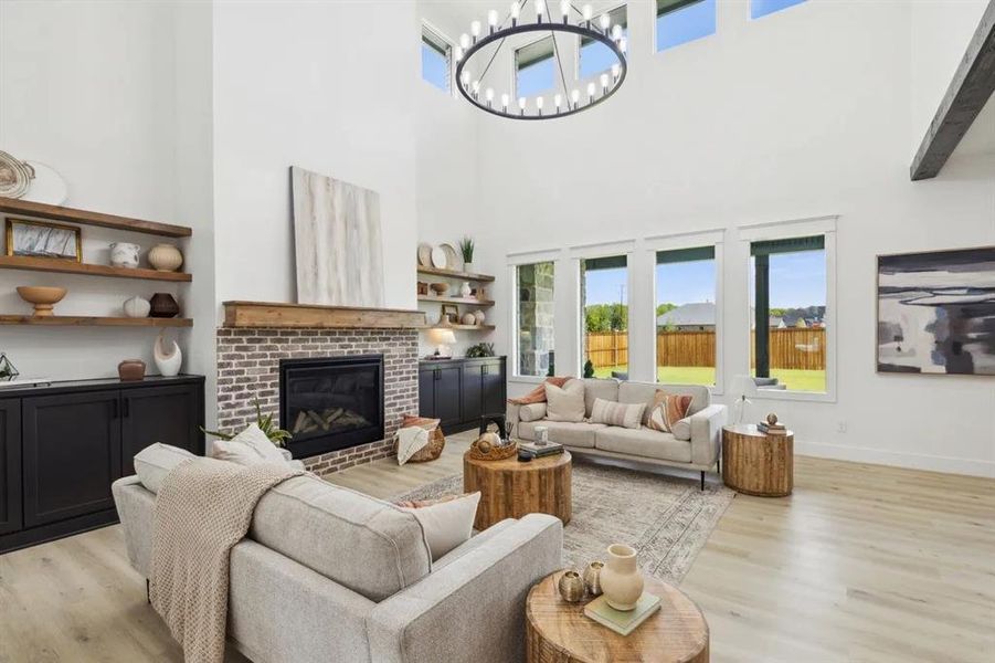 Living area with wood finished floors, a fireplace, hanging lights, and a high ceiling