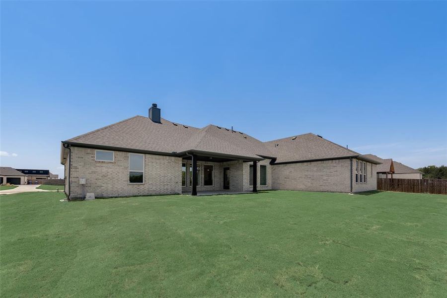 Rear view of house featuring a patio area and a lawn