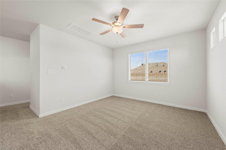 An airy bedroom with fresh carpeting and a ceiling fan, offering a comfortable personal retreat.