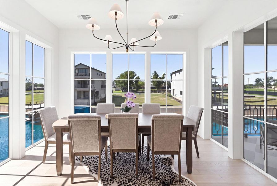 A spacious dining area features abundant natural light and waterfront views, ideal for gatherings. A spacious dining area features abundant natural light and waterfront views, ideal for gatherings.