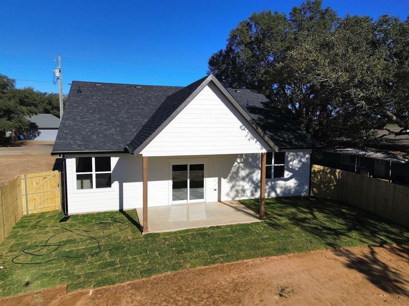 Back of property with a yard and a patio area