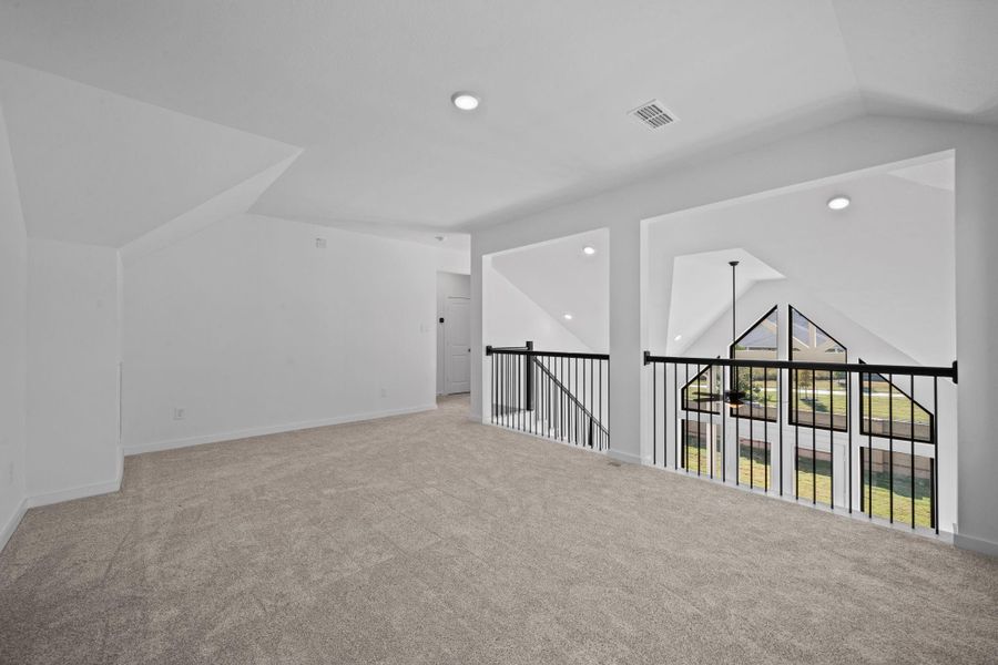The upstairs gameroom is an expansive, open space designed for entertainment and relaxation, with high ceilings and upgraded railing to view the space below. It can easily accommodate a variety of activities—from gaming tables and media centers to lounge areas—making it the ultimate hub for fun and socializing.