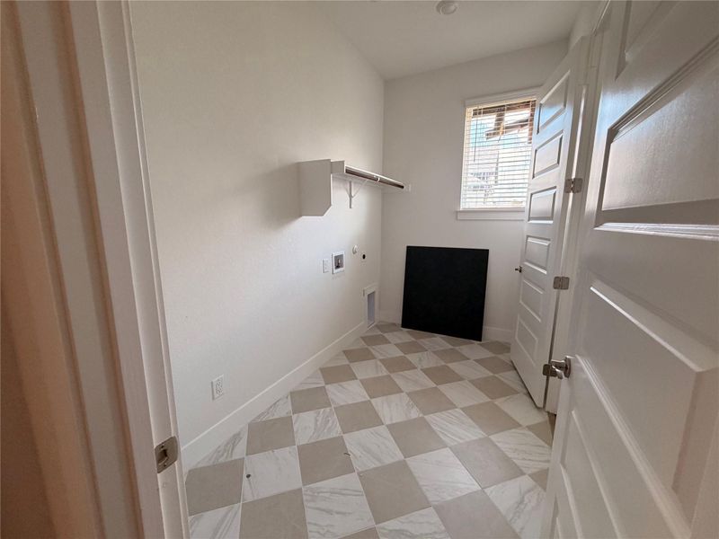 A well-lit laundry area with patterned floor tiles and a window for natural light. A well-lit laundry area with patterned floor tiles and a window for natural light.