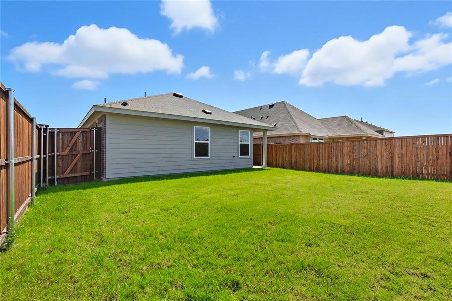 Back of house with a fenced backyard and a gate Back of house with a fenced backyard and a gate