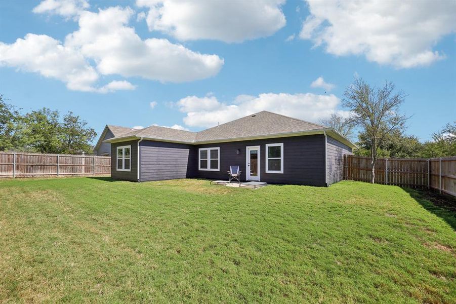 Back of property featuring a fenced backyard, a patio, and a shingled roof Back of property featuring a fenced backyard, a patio, and a shingled roof