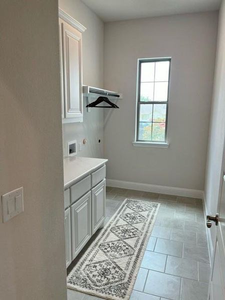 Laundry area featuring hookup for a washing machine, cabinet space, and hookup for an electric dryer Laundry area featuring hookup for a washing machine, cabinet space, and hookup for an electric dryer