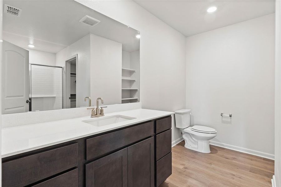 Bathroom with light wood-style flooring, vanity, recessed lighting, and a shower stall