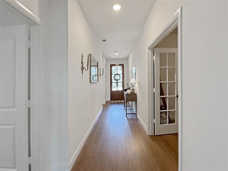 Hallway with light wood-type flooring and recessed lighting Hallway with light wood-type flooring and recessed lighting