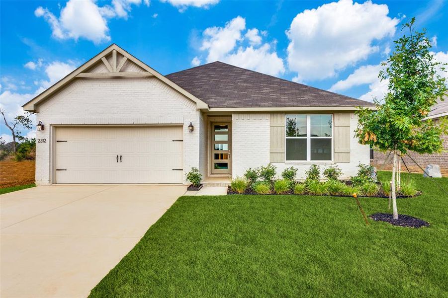 View of front of home featuring a garage and a front lawn