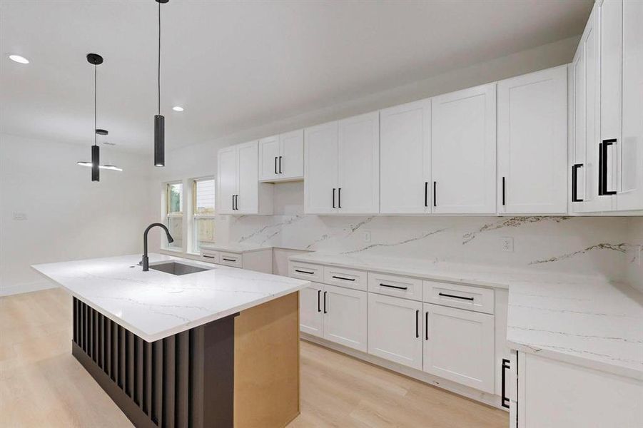 Kitchen featuring backsplash, light wood finished floors, light stone counters, white cabinets, and recessed lighting Kitchen featuring backsplash, light wood finished floors, light stone counters, white cabinets, and recessed lighting