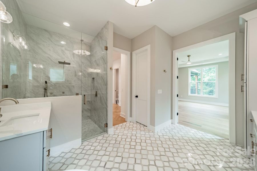 Your stunning Master Suite boasts beautiful custom lighting, cabinetry, tilework, a soaking tub, and a spacious shower.