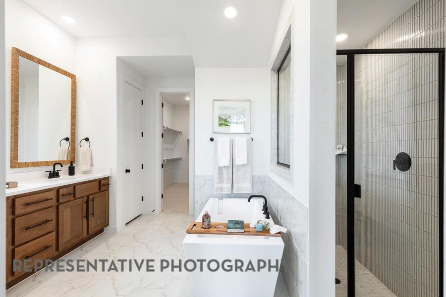 Full bathroom featuring a shower stall, marble finish flooring, a freestanding tub, vanity, and recessed lighting