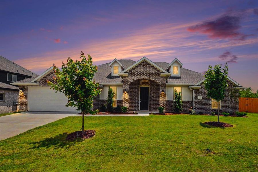 Brick exterior with a prominent arched entry, contrasting white trim, a two-car garage, and a gabled roofline Brick exterior with a prominent arched entry, contrasting white trim, a two-car garage, and a gabled roofline