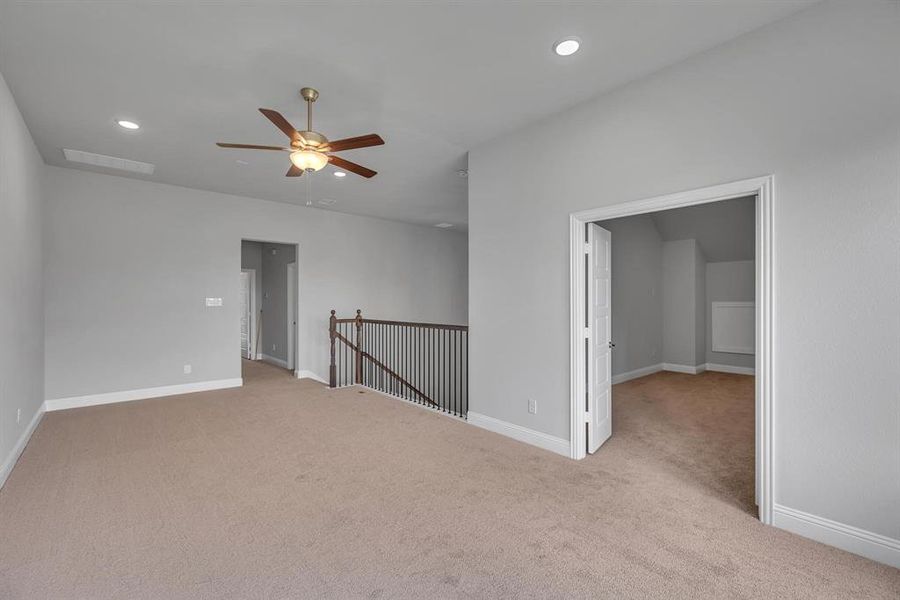 Carpeted empty room featuring ceiling fan