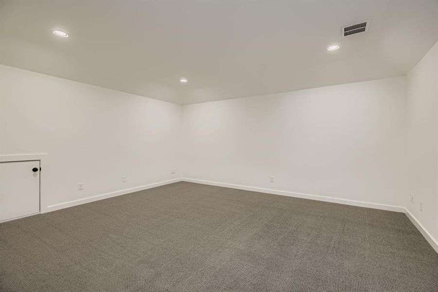 Spare room featuring dark carpet and recessed lighting Spare room featuring dark carpet and recessed lighting