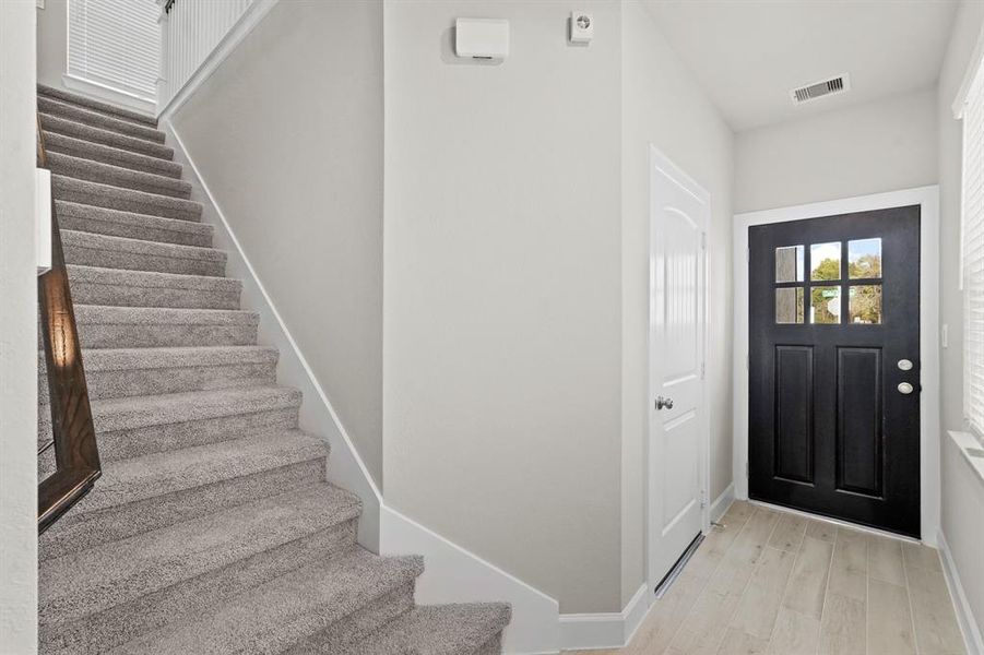 Welcoming entry with stairs that lead up or door to the garage down (*Photo not of actual home and used for illustration purposes only.)