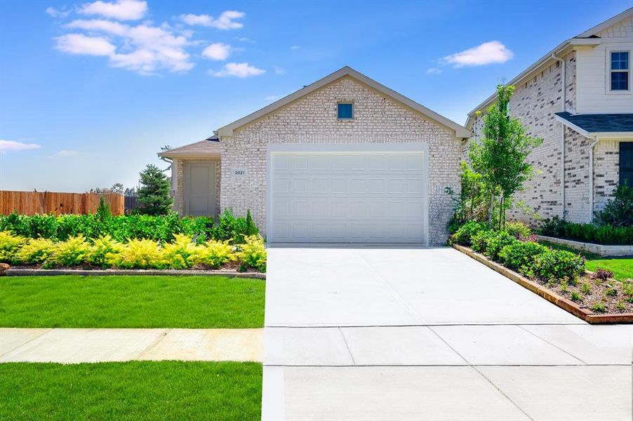 View of front of property featuring a garage and a front yard