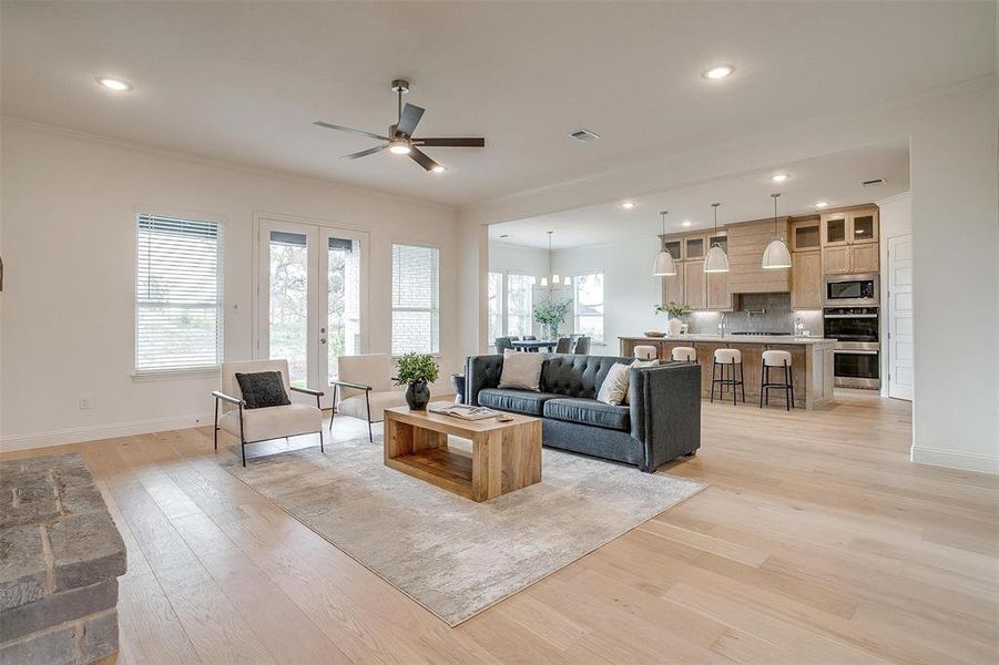 Living room with french doors, crown molding, light wood-type flooring, and ceiling fan, 10 ft ceilings and 8 ft doors