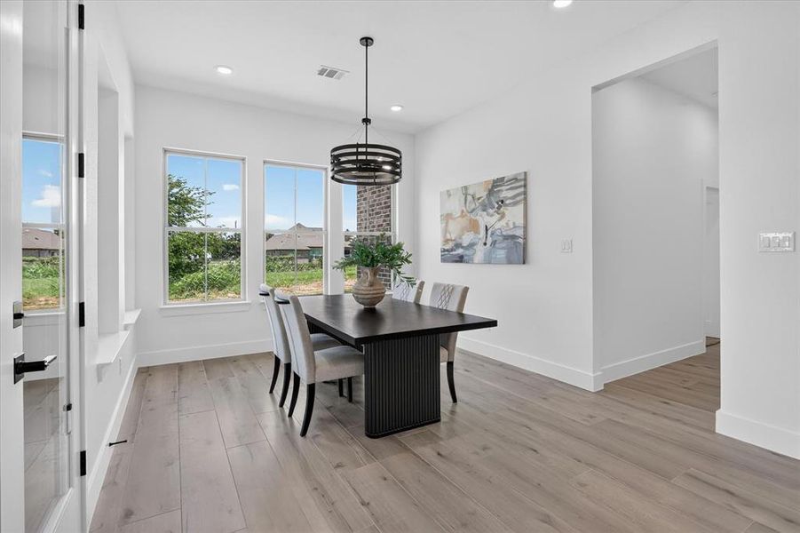 Dining space featuring wood-finish flooring, recessed lighting, and a modern circular chandelier