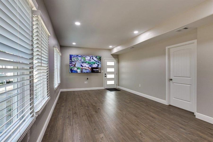 Foyer with healthy amount of natural light, dark wood-style flooring, and recessed lighting