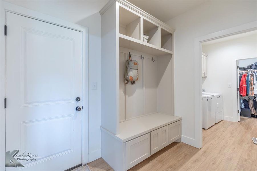 Mudroom with light wood-style flooring and washing machine and clothes dryer Mudroom with light wood-style flooring and washing machine and clothes dryer