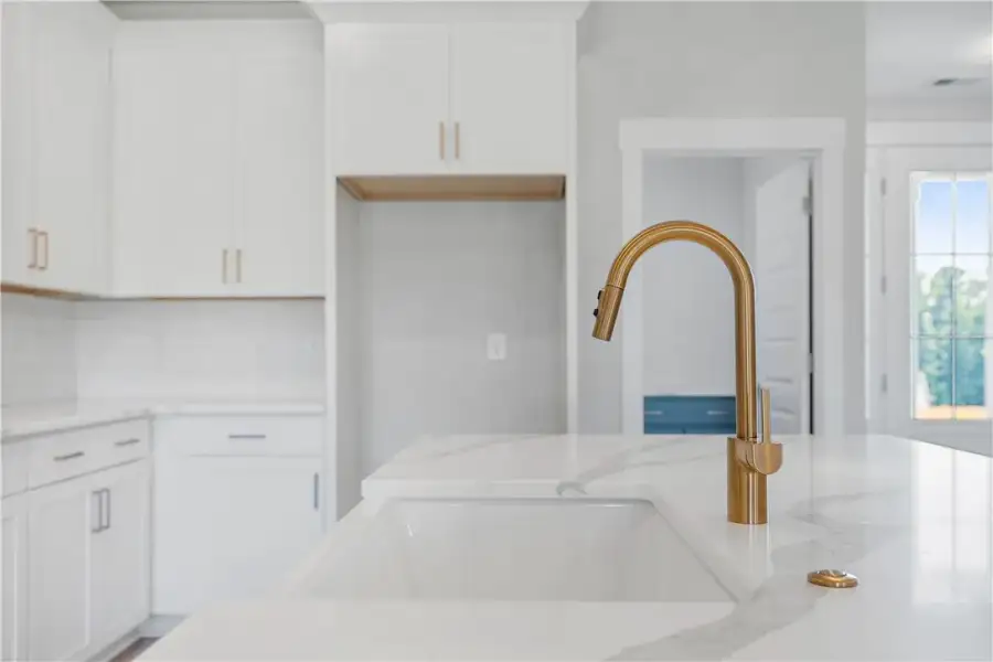A sleek gold-toned faucet rises elegantly above a A sleek gold-toned faucet rises elegantly above a
