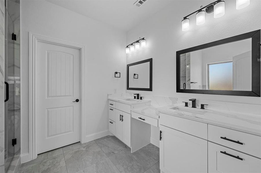 Bathroom featuring vanity, tile patterned flooring, and a shower with door