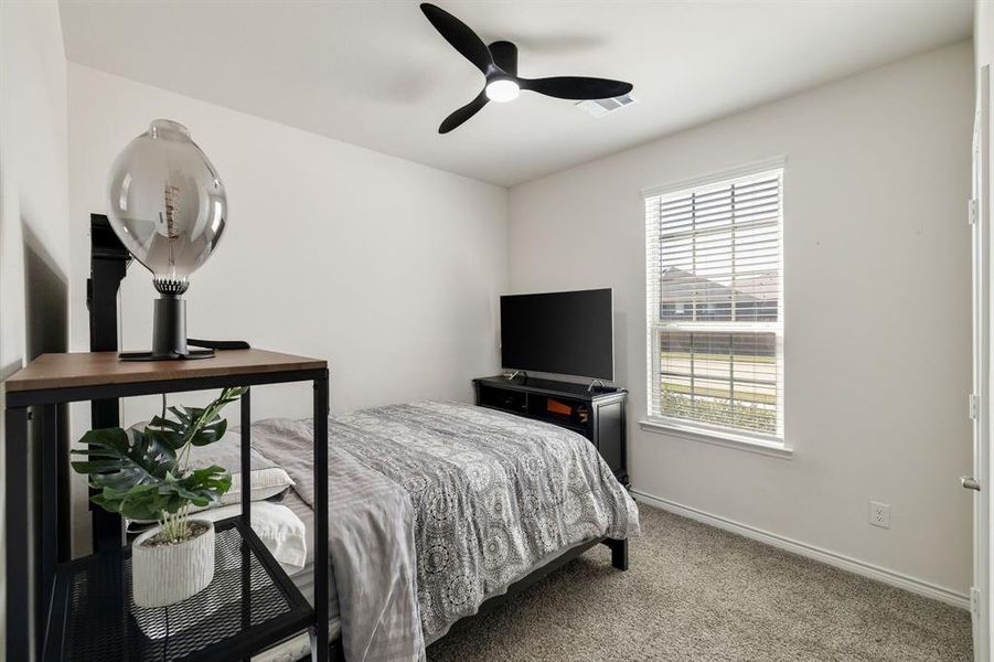 Carpeted bedroom with baseboards and a ceiling fan Carpeted bedroom with baseboards and a ceiling fan