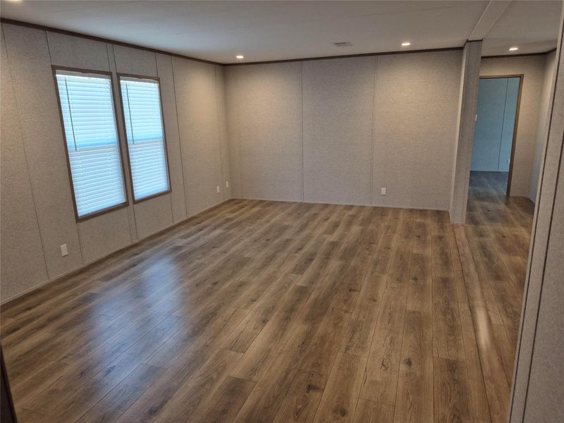 Unfurnished room featuring dark wood-style flooring, recessed lighting, and a decorative wall