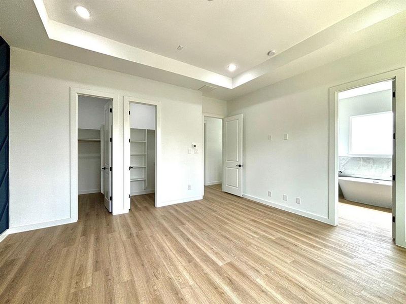 The handsome and spacious primary suite features coffered ceiling and two generous walk-in closets and an en suite bathroom.