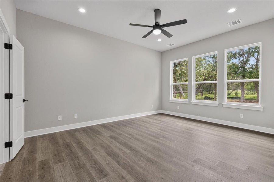 A well-lit interior space features sleek wood flooring, recessed lighting, and a modern ceiling fan, creating an inviting atmosphere. A well-lit interior space features sleek wood flooring, recessed lighting, and a modern ceiling fan, creating an inviting atmosphere.