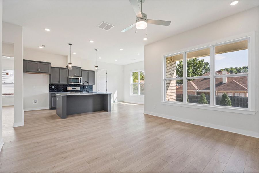 Open-concept living space featuring wood-finish flooring, recessed lighting, and a ceiling fan