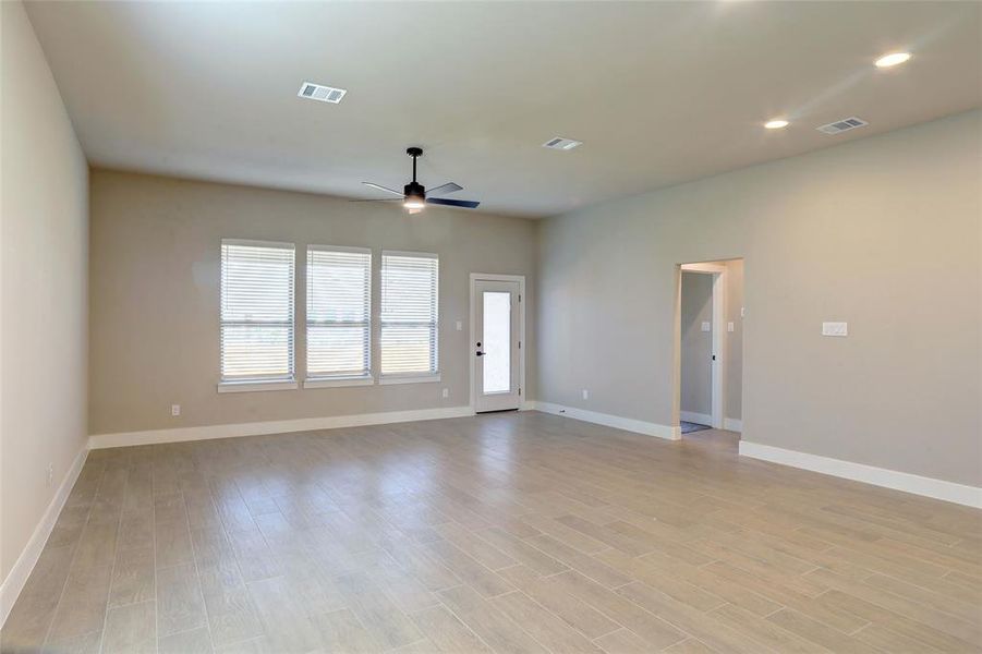 Empty room with ceiling fan, light wood-type flooring, and recessed lighting Empty room with ceiling fan, light wood-type flooring, and recessed lighting