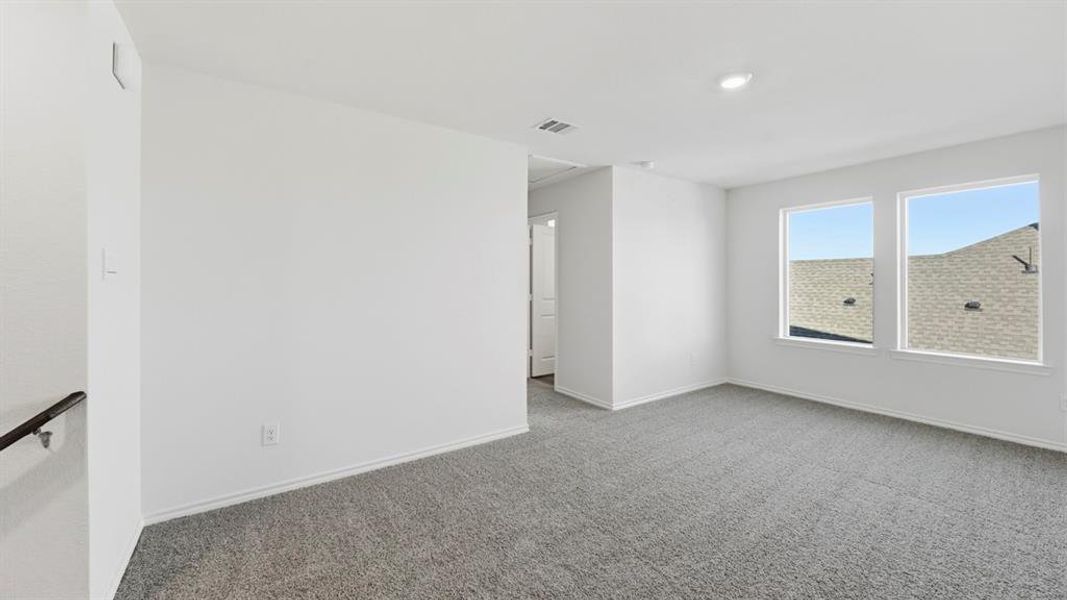 Carpeted empty room featuring baseboards
