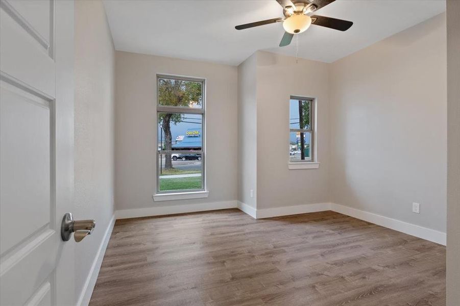 Empty room featuring wood-type flooring, ceiling fan, and plenty of natural light