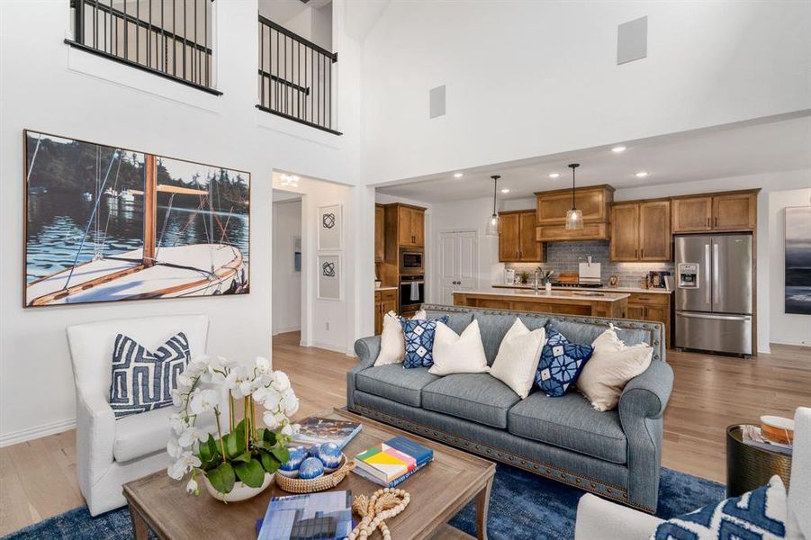 Living room with a towering ceiling and light hardwood / wood-style flooring