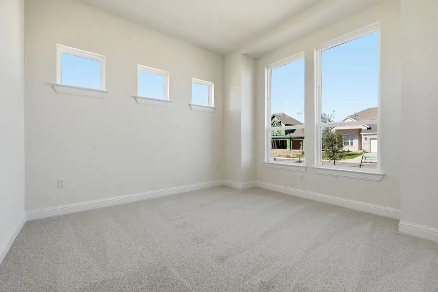 Empty room with light carpet and healthy amount of natural light