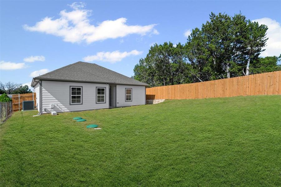 Rear view of house featuring a fenced backyard and a shingled roof Rear view of house featuring a fenced backyard and a shingled roof
