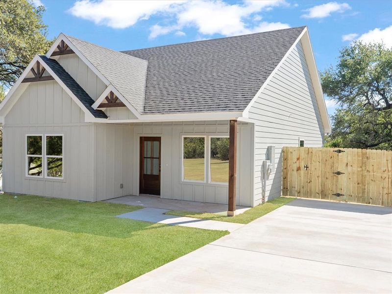 View of front facade with roof with shingles, board and batten siding, and a gate View of front facade with roof with shingles, board and batten siding, and a gate