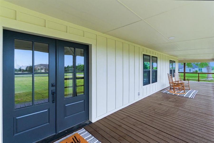 Inviting covered front porch with a wooden floor and white board-and-batten siding Inviting covered front porch with a wooden floor and white board-and-batten siding