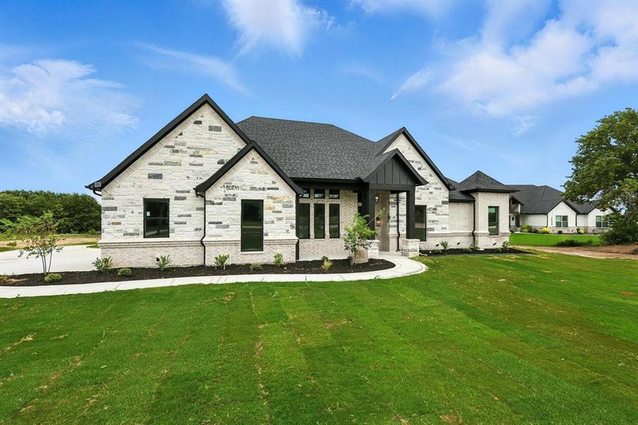 View of front of house with a front lawn and stone siding View of front of house with a front lawn and stone siding