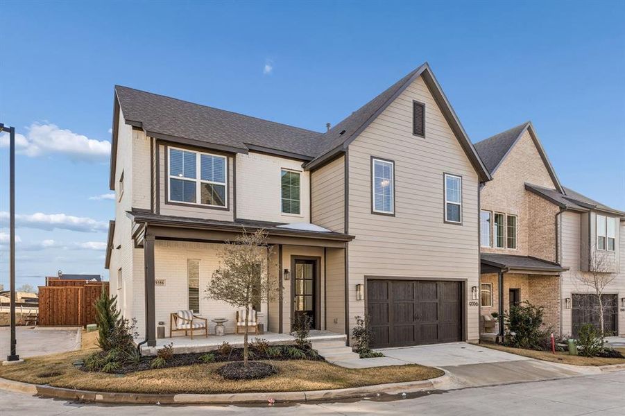 Traditional home with brick siding, a porch, a garage, and driveway
