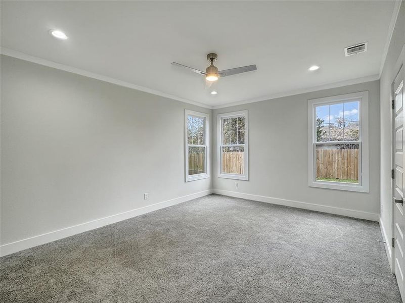 Spare room with carpet floors, a ceiling fan, crown molding, healthy amount of natural light, and recessed lighting Spare room with carpet floors, a ceiling fan, crown molding, healthy amount of natural light, and recessed lighting