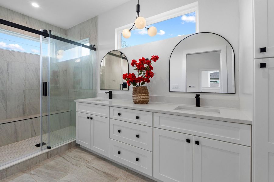 Clean lines and stone surfaces define this modern washroom featuring a spacious glass shower.