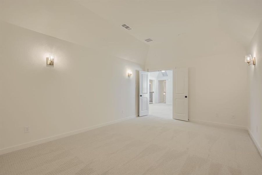 Carpeted empty room with baseboards and lofted ceiling