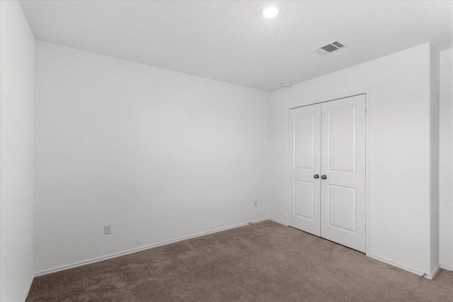Unfurnished bedroom with dark colored carpet and a closet