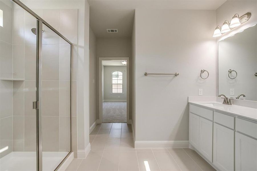 Bathroom with vanity, tile patterned floors, and a shower stall Bathroom with vanity, tile patterned floors, and a shower stall